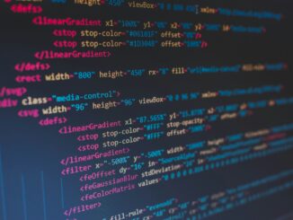 Mão de usuário interagindo com um laptop com tela escura e ícones de alerta de fraude e cadeado.